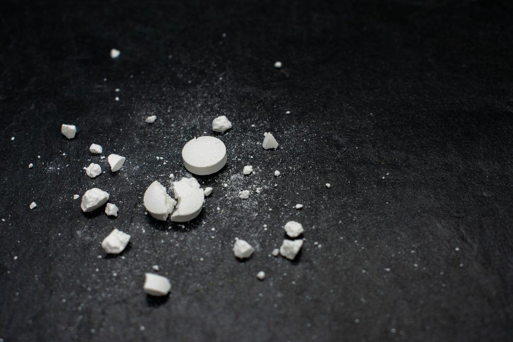 crushed up pill on black background