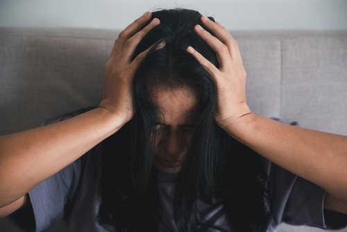 woman with hands on her head being angry