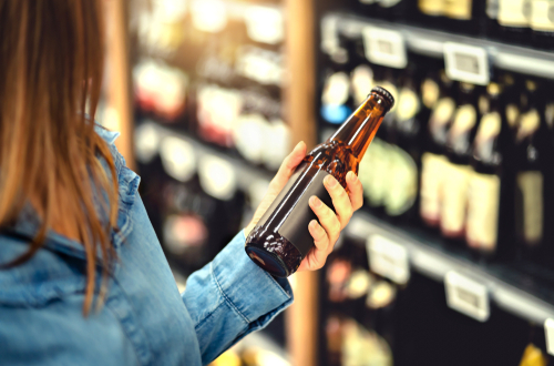 woman holding a blank beer bottle 