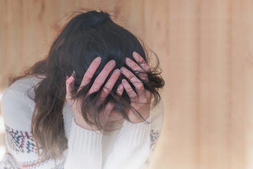 woman with her head in her hands looking down